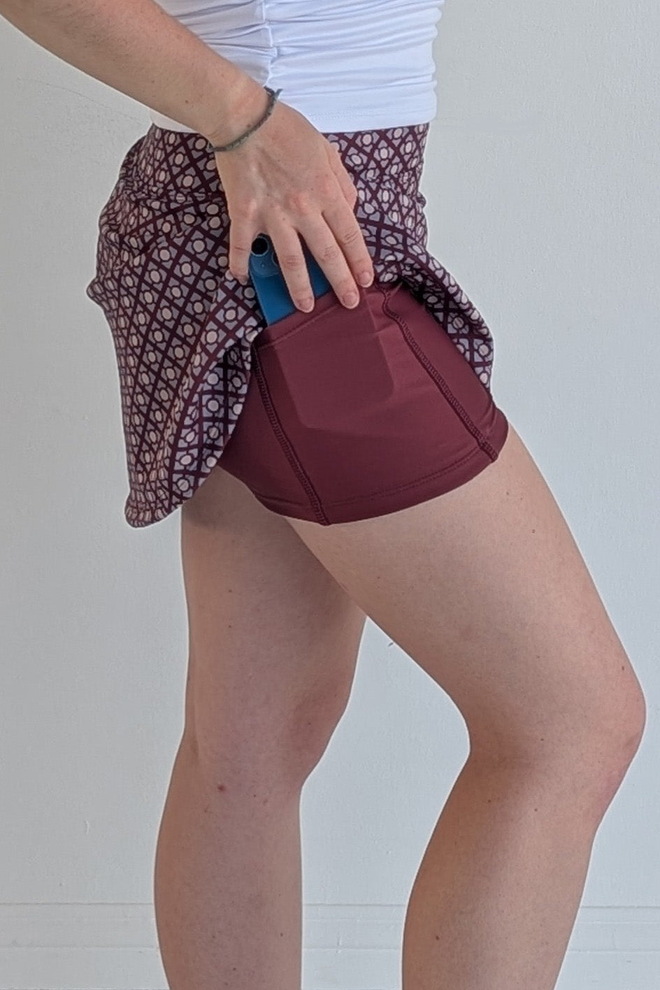 Form Fitting maroon miniskirt with geometric print and built in shorts and pockets; great for gameday or hanging out with friends.