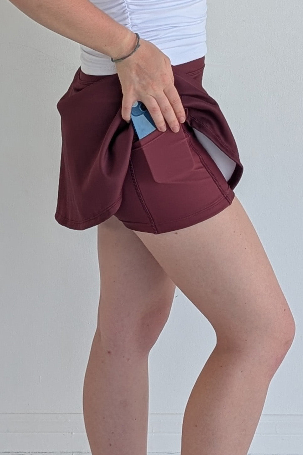 Relaxed back solid maroon miniskirt with built in shorts and pockets; great for gameday or hanging out with friends.