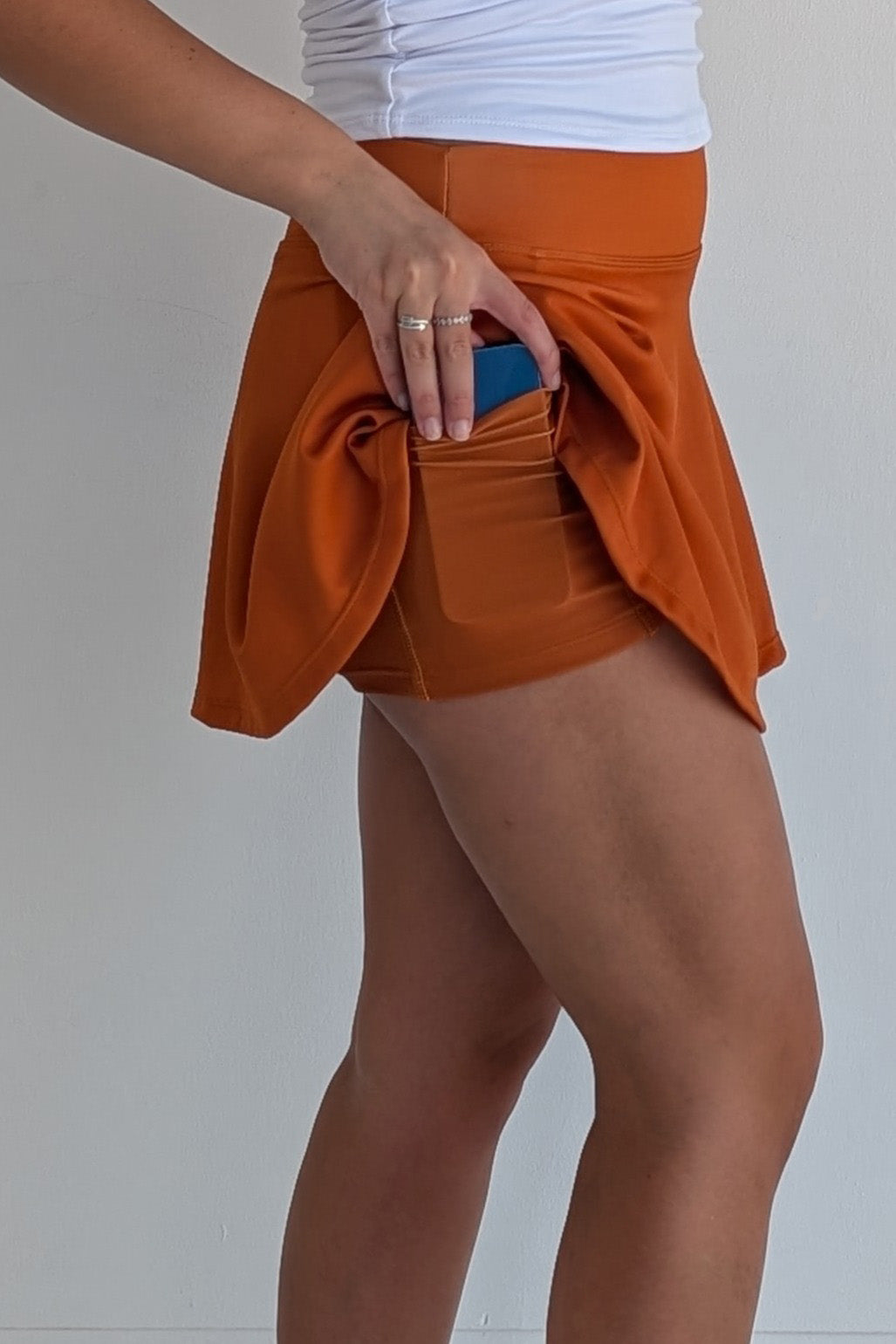 Full bodied solid burnt orange miniskirt with built in shorts and pockets; great for gameday or hanging out with friends.