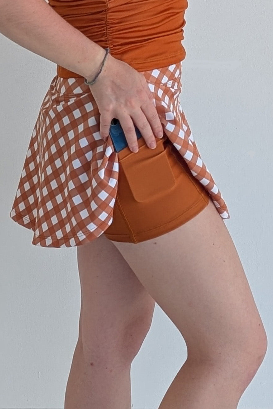 Full bodied burnt orange gingham miniskirt with built in shorts and pockets; great for gameday or hanging out with friends.