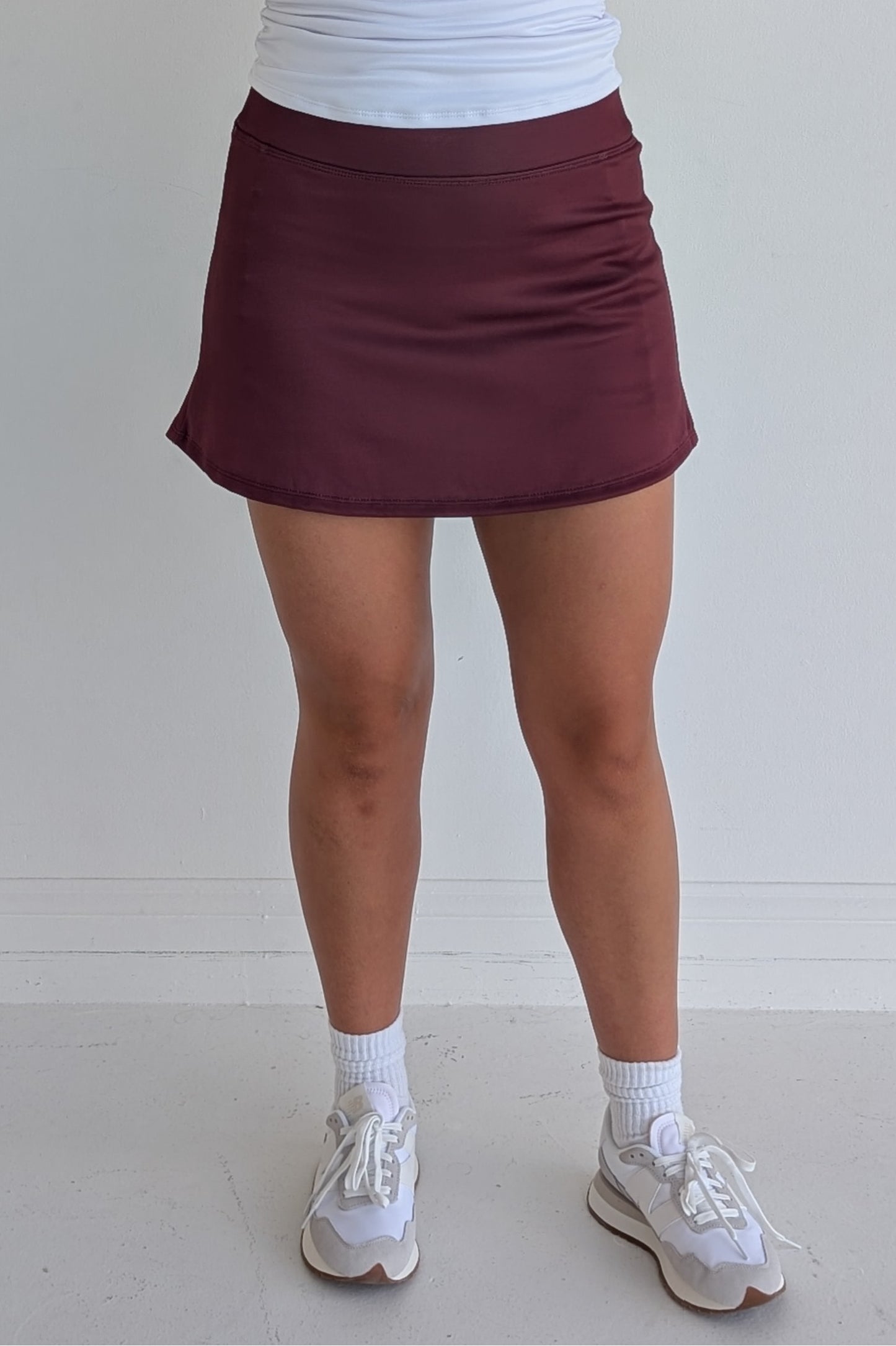 Form Fitting solid maroon miniskirt with built in shorts and pockets; great for gameday or hanging out with friends.