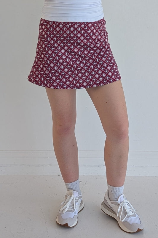 Form Fitting crimson miniskirt with geometric print and built in shorts and pockets; great for gameday or hanging out with friends.