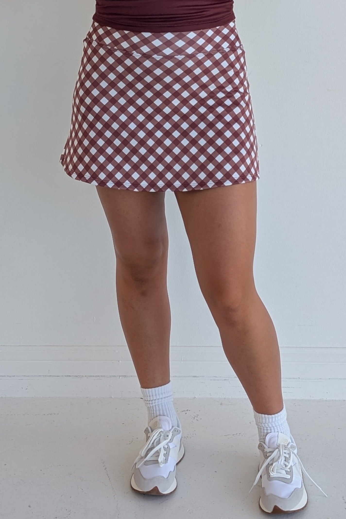 Form Fitting maroon gingham miniskirt with  built in shorts and pockets; great for gameday or hanging out with friends.