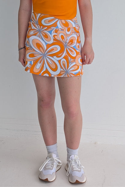 Form Fitting orange miniskirt with 70's inspired flower print and built in shorts and pockets; great for gameday or hanging out with friends.