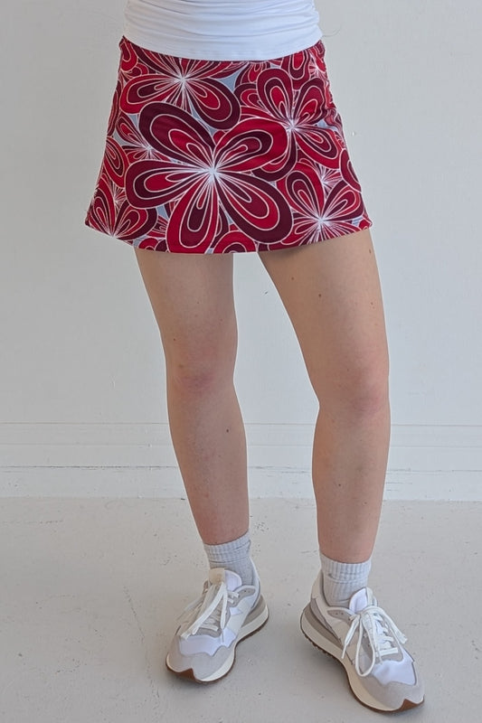 Form Fitting crimson miniskirt with 70's inspired flower print and built in shorts and pockets; great for gameday or hanging out with friends.