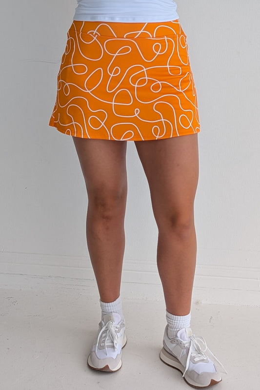 Form Fitting orange miniskirt with scribbles print and built in shorts and pockets; great for gameday or hanging out with friends.
