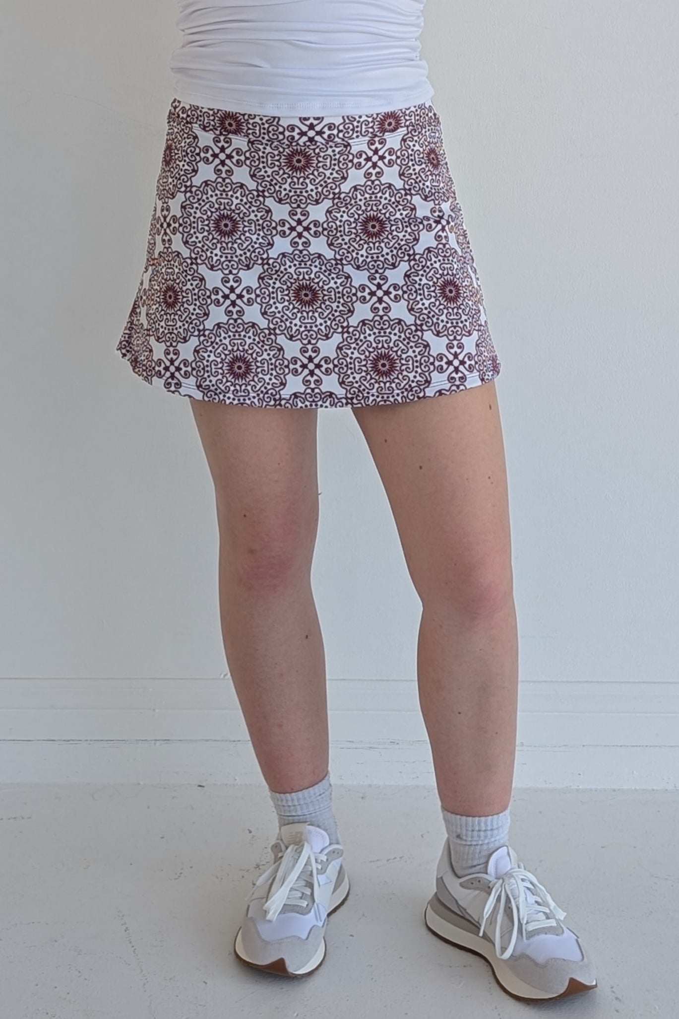 Form Fitting maroon miniskirt with scroll print and built in shorts and pockets; great for gameday or hanging out with friends.