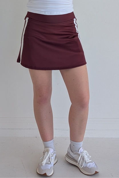 Form Fitting maroon miniskirt with side stripes and built in shorts and pockets; great for gameday or hanging out with friends.