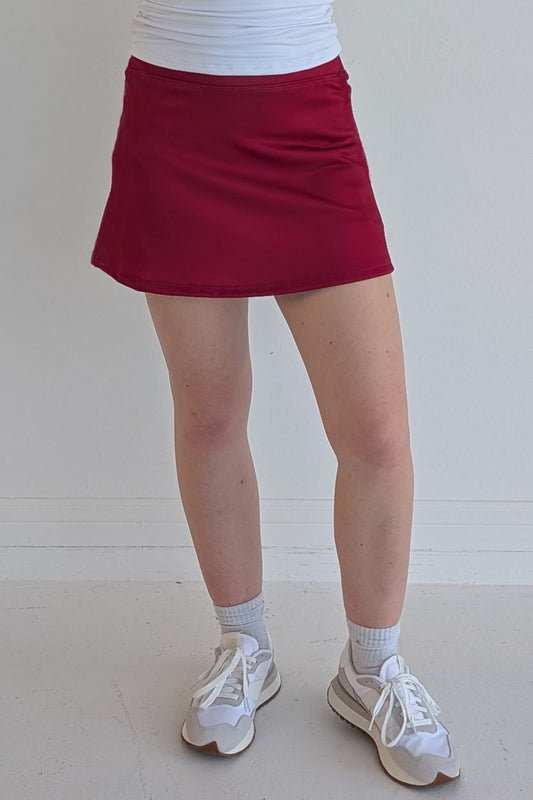 Form Fitting solid crimson miniskirt with built in shorts and pockets; great for gameday or hanging out with friends.