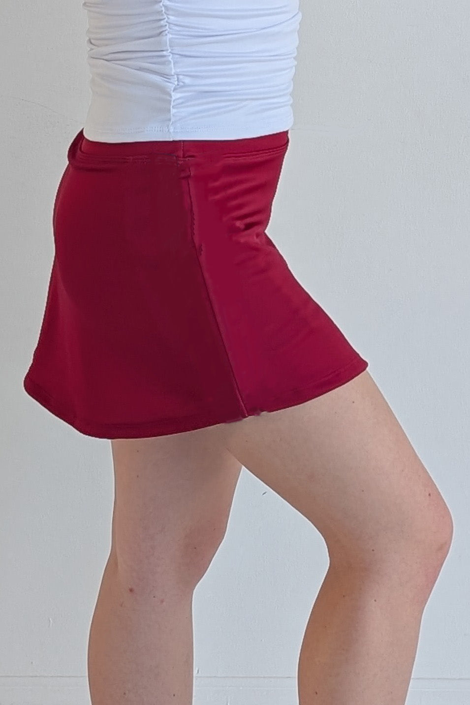 Form Fitting solid crimson miniskirt with built in shorts and pockets; great for gameday or hanging out with friends.