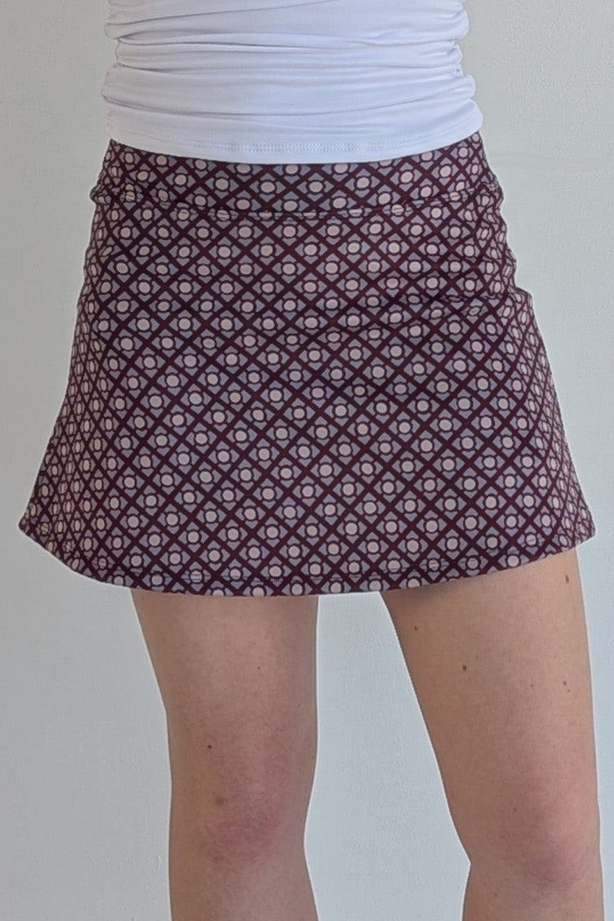 Form Fitting maroon miniskirt with geometric print and built in shorts and pockets; great for gameday or hanging out with friends.
