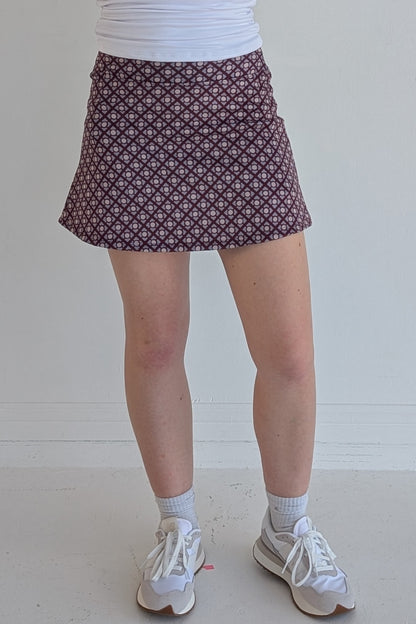 Form Fitting maroon miniskirt with geometric print and built in shorts and pockets; great for gameday or hanging out with friends.