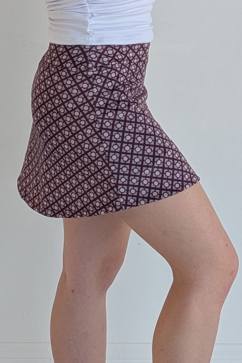 Form Fitting maroon miniskirt with geometric print and built in shorts and pockets; great for gameday or hanging out with friends.