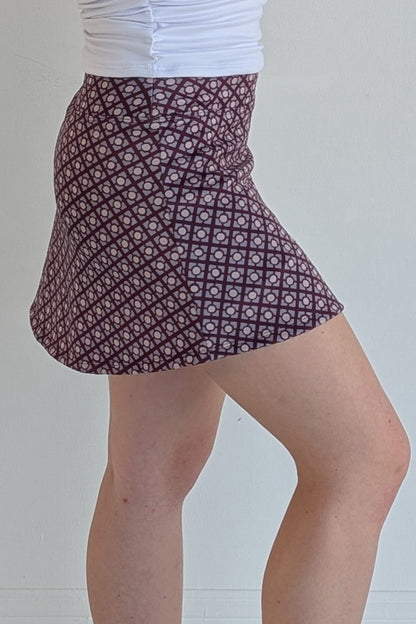 Form Fitting maroon miniskirt with geometric print and built in shorts and pockets; great for gameday or hanging out with friends.