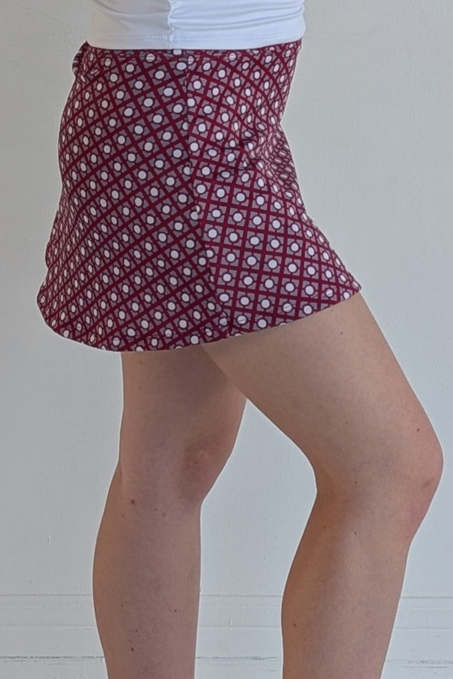 Form Fitting crimson miniskirt with geometric print and built in shorts and pockets; great for gameday or hanging out with friends.