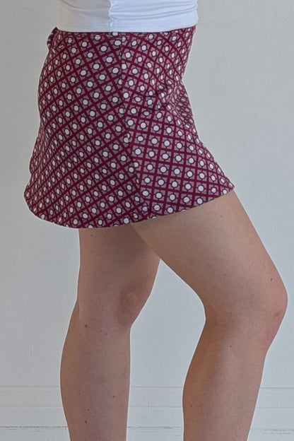 Form Fitting crimson miniskirt with geometric print and built in shorts and pockets; great for gameday or hanging out with friends.