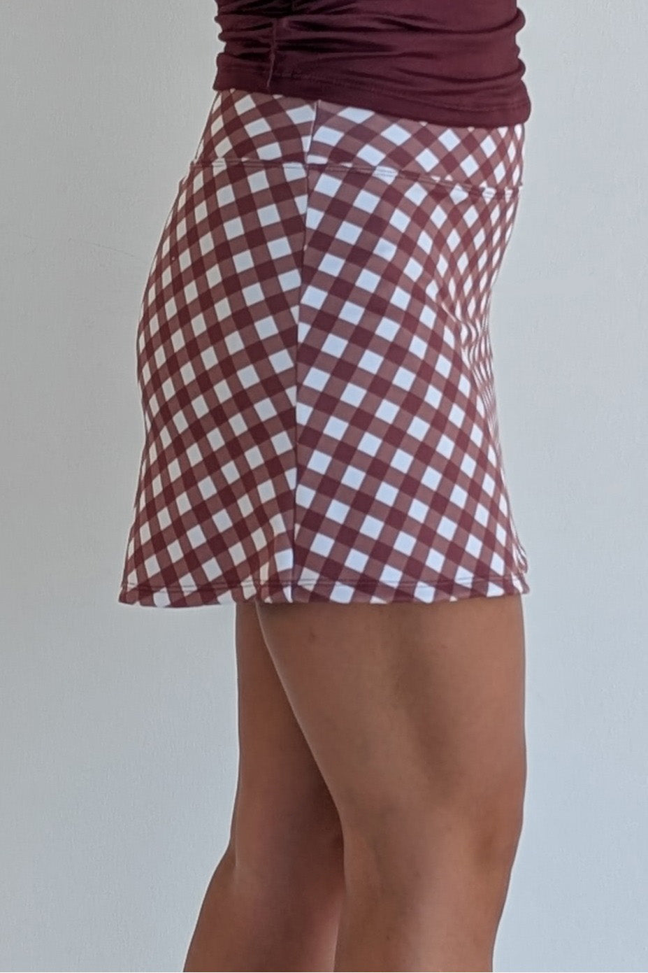 Form Fitting maroon gingham miniskirt with  built in shorts and pockets; great for gameday or hanging out with friends.