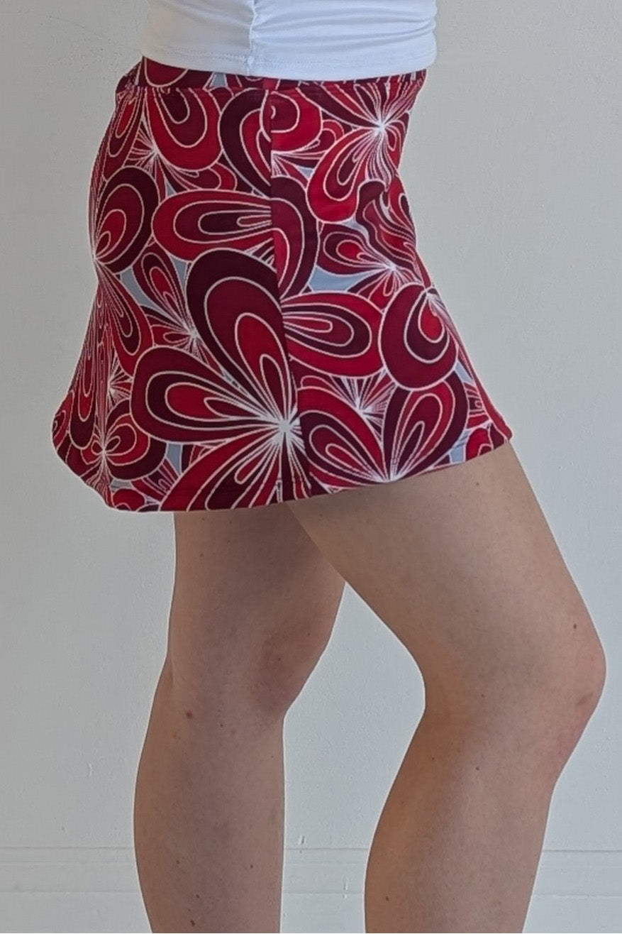 Form Fitting crimson miniskirt with 70's inspired flower print and built in shorts and pockets; great for gameday or hanging out with friends.