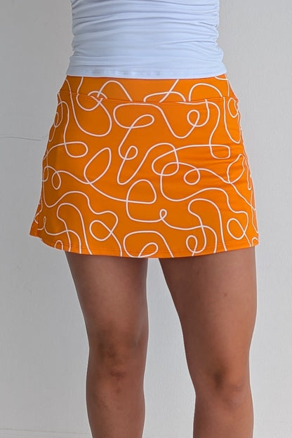 Form Fitting orange miniskirt with scribbles print and built in shorts and pockets; great for gameday or hanging out with friends.