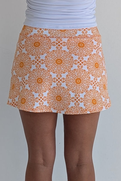 Form Fitting orange miniskirt with scroll print and built in shorts and pockets; great for gameday or hanging out with friends.