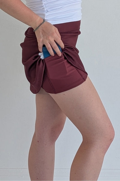 Form Fitting maroon miniskirt with side stripes and built in shorts and pockets; great for gameday or hanging out with friends.