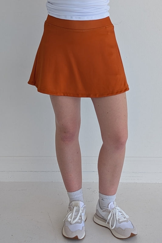 Relaxed back solid burnt orange miniskirt with built in shorts and pockets; great for gameday or hanging out with friends.