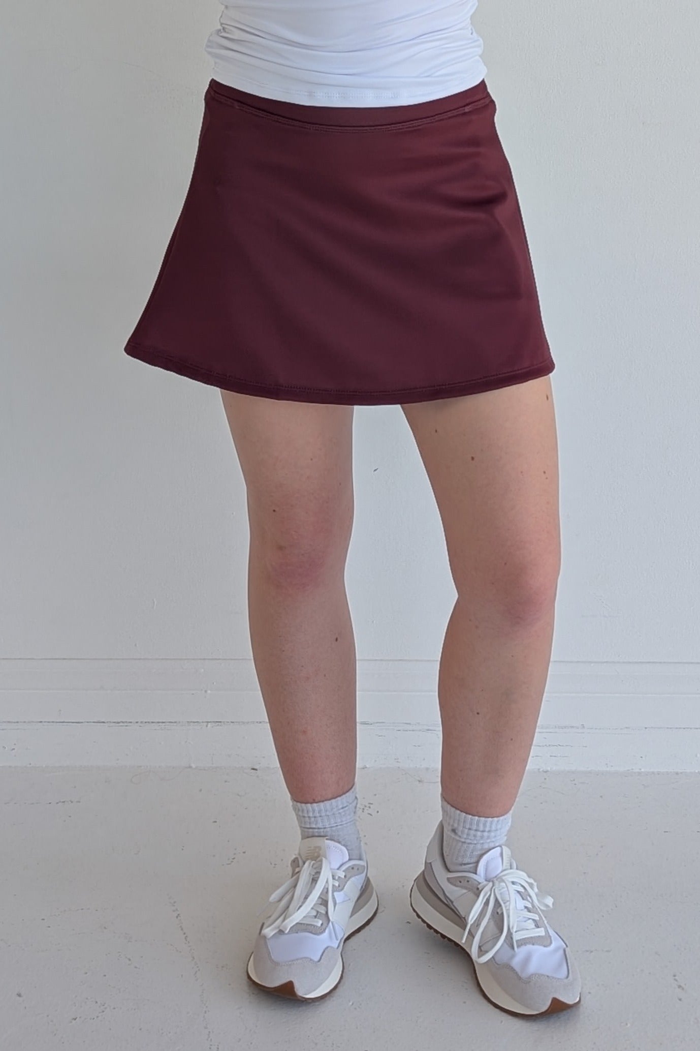 Relaxed back solid maroon miniskirt with built in shorts and pockets; great for gameday or hanging out with friends.