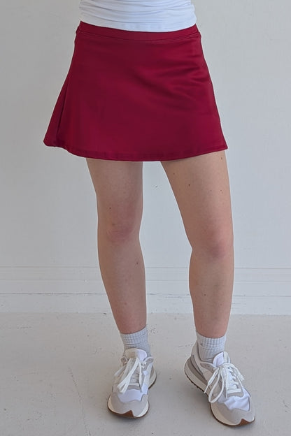 Relaxed back solid crimson miniskirt with built in shorts and pockets; great for gameday or hanging out with friends.