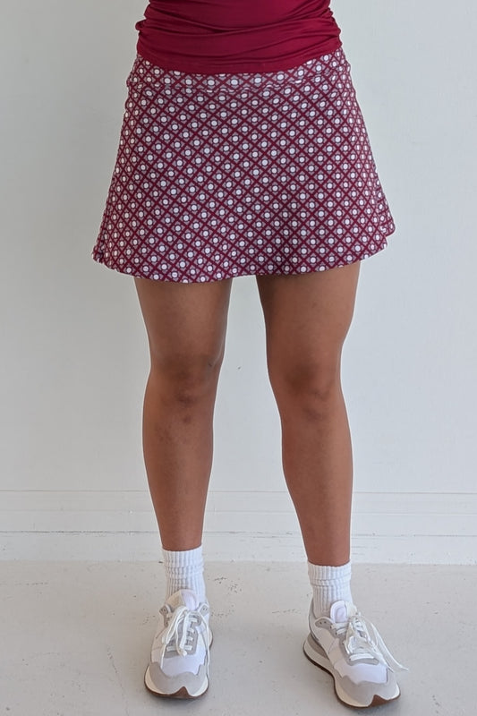 Relaxed back crimson miniskirt with geometric print and built in shorts and pockets; great for gameday or hanging out with friends.