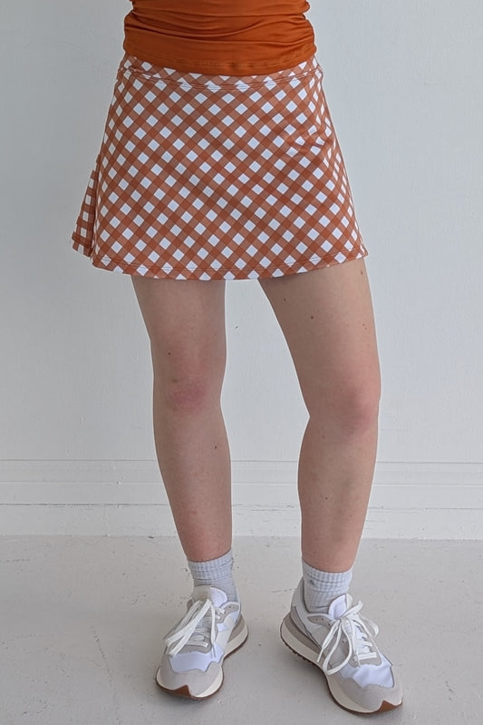 Relaxed back burnt orange gingham miniskirt with  built in shorts and pockets; great for gameday or hanging out with friends.