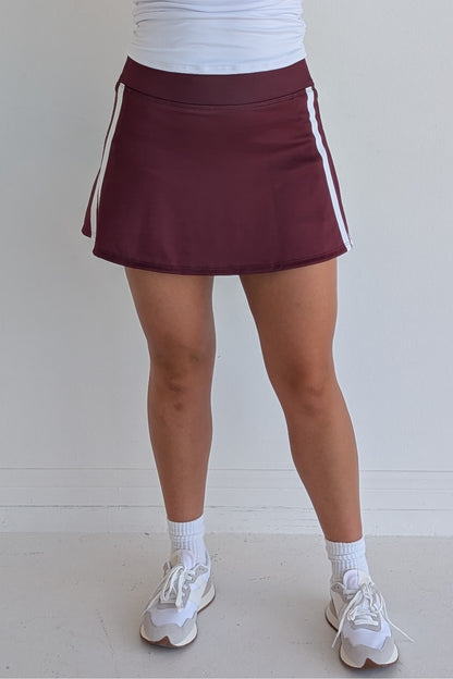 Relaxed back maroon miniskirt with side stripes and built in shorts and pockets; great for gameday or hanging out with friends.