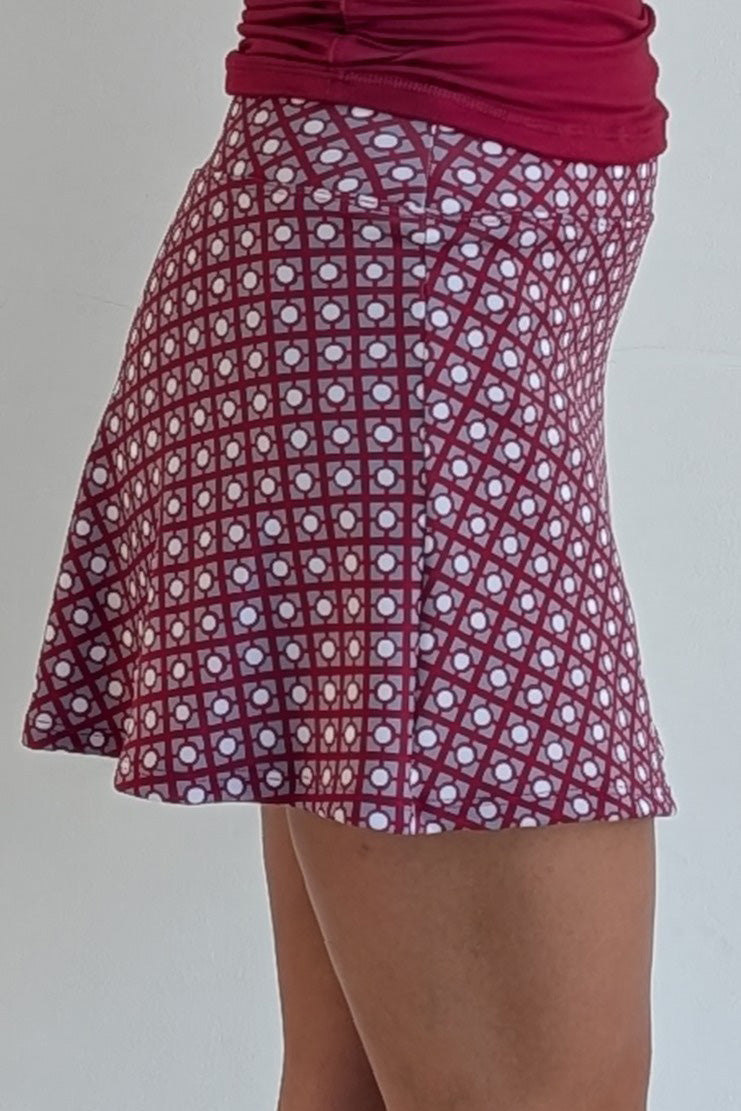 Relaxed back crimson miniskirt with geometric print and built in shorts and pockets; great for gameday or hanging out with friends.
