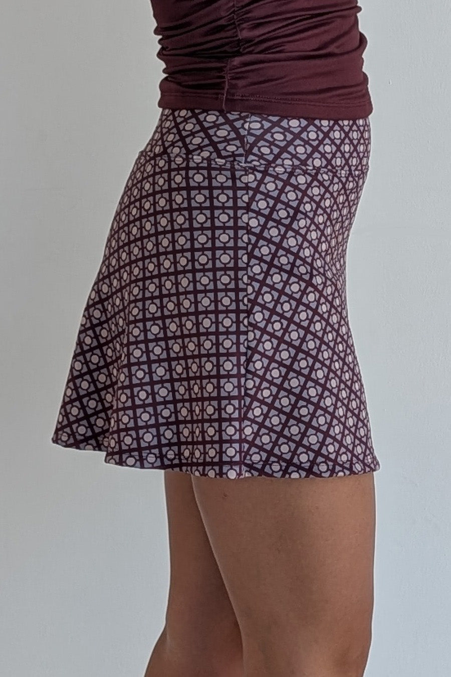 Relaxed back maroon miniskirt with geometric print and built in shorts and pockets; great for gameday or hanging out with friends.