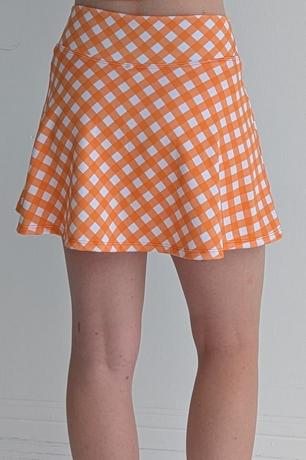 Relaxed back orange gingham miniskirt with  built in shorts and pockets; great for gameday or hanging out with friends.