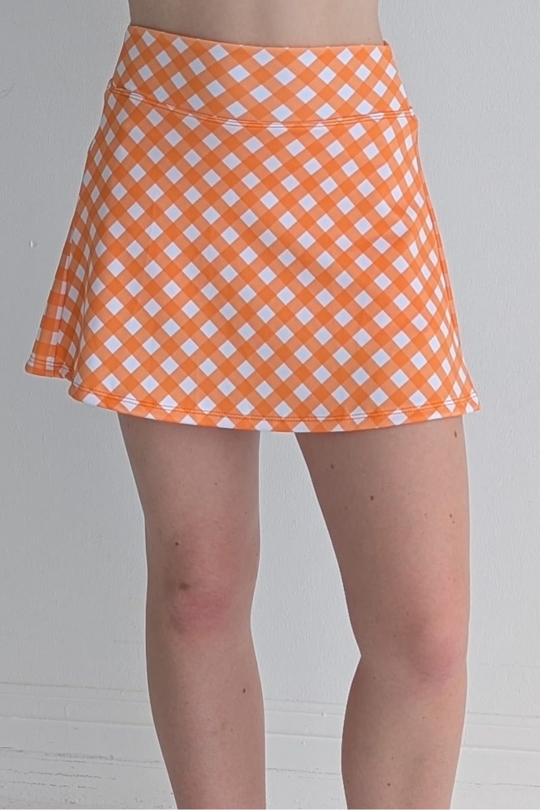 Relaxed back orange gingham miniskirt with  built in shorts and pockets; great for gameday or hanging out with friends.