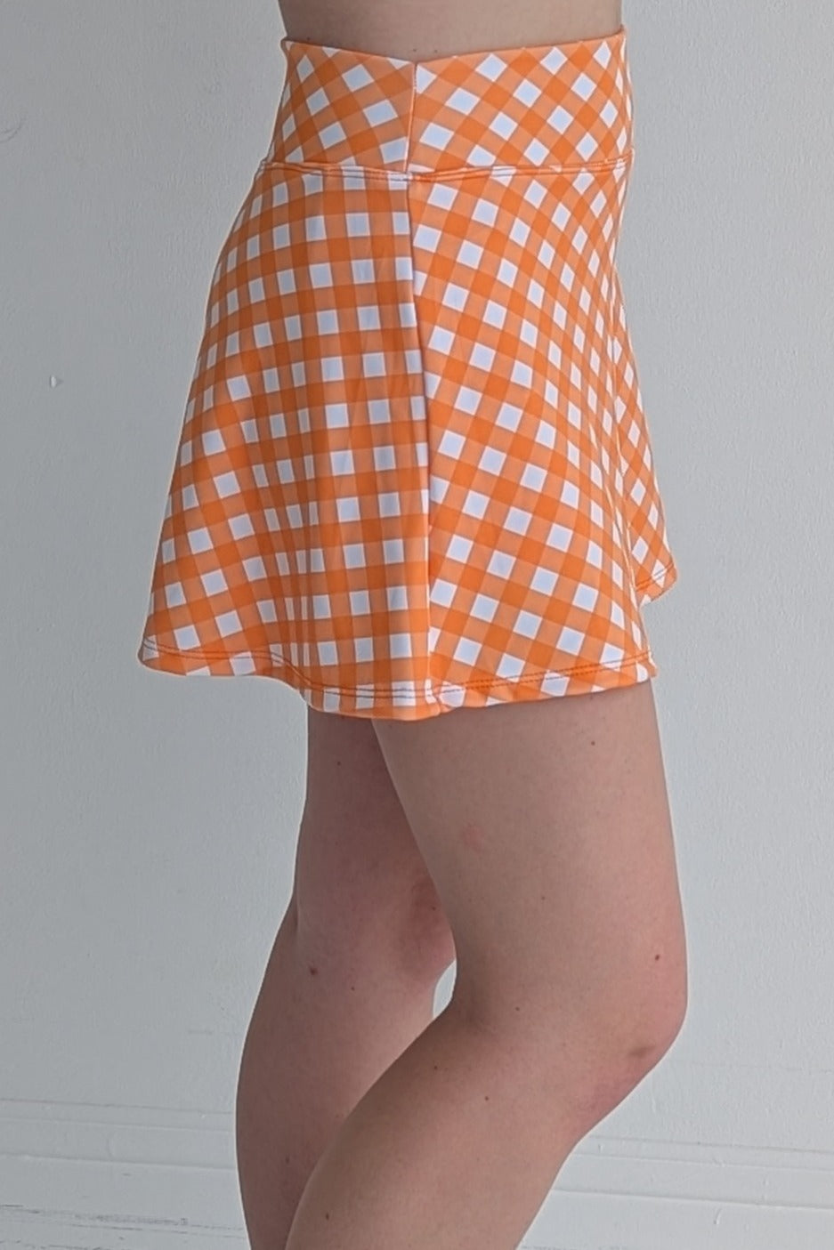 Relaxed back orange gingham miniskirt with  built in shorts and pockets; great for gameday or hanging out with friends.