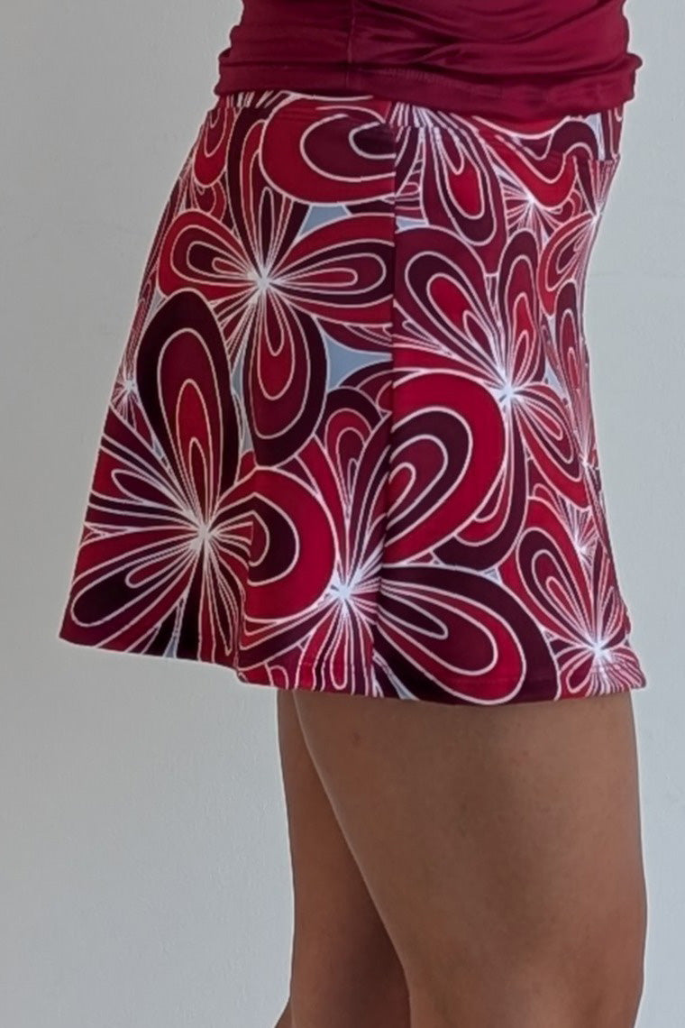 Relaxed back crimson miniskirt with 70's inspired flower print and built in shorts and pockets; great for gameday or hanging out with friends.