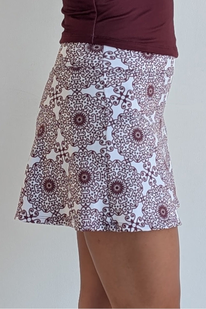 Relaxed back maroon miniskirt with scroll print and built in shorts and pockets; great for gameday or hanging out with friends.