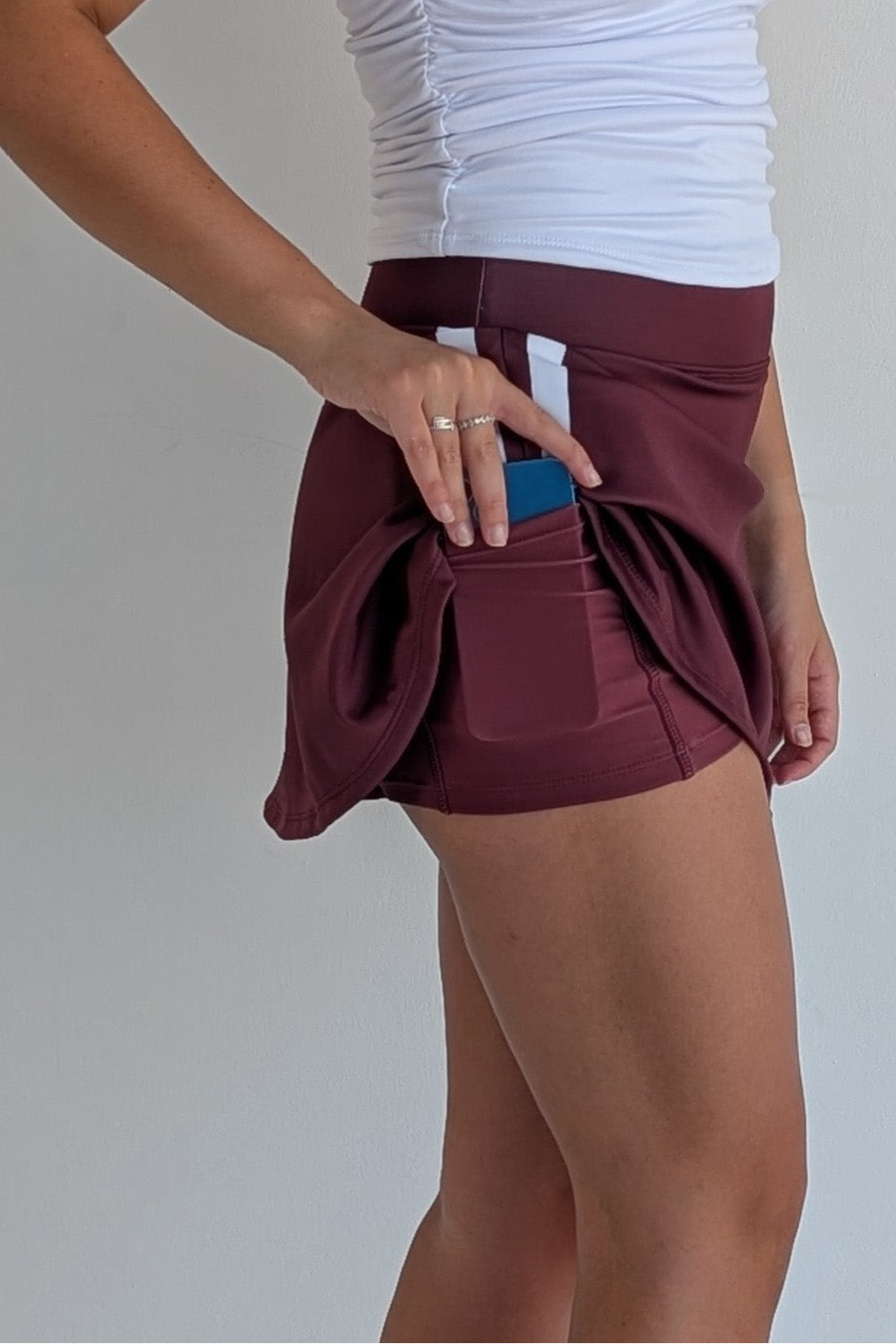 Relaxed back maroon miniskirt with side stripes and built in shorts and pockets; great for gameday or hanging out with friends.