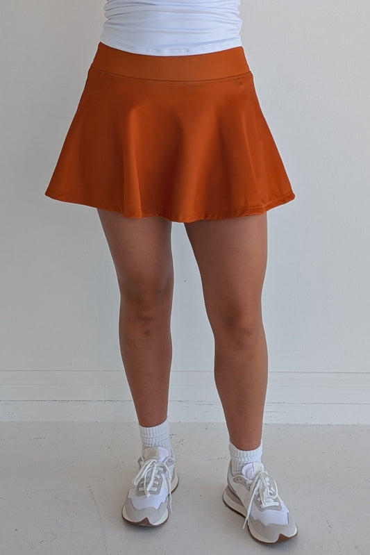 Full bodied solid burnt orange miniskirt with built in shorts and pockets; great for gameday or hanging out with friends.