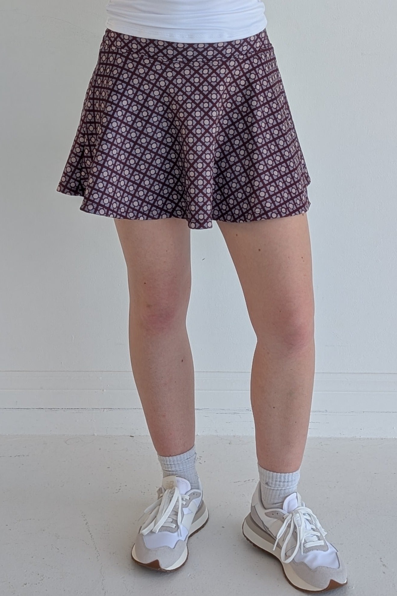 Full bodied maroon miniskirt with geometric print and built in shorts and pockets; great for gameday or hanging out with friends.
