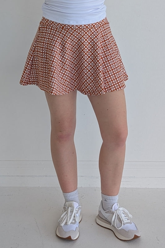 Full bodied burnt orange miniskirt with geometric print and built in shorts and pockets; great for gameday or hanging out with friends.