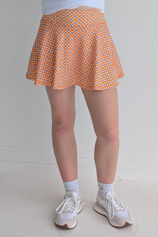 Full bodied orange miniskirt with geometric print and built in shorts and pockets; great for gameday or hanging out with friends.
