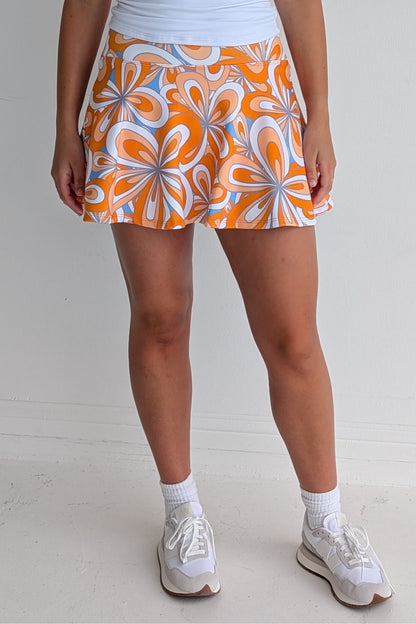 Full bodied orange miniskirt with 70's inspired flower print and built in shorts and pockets; great for gameday or hanging out with friends.