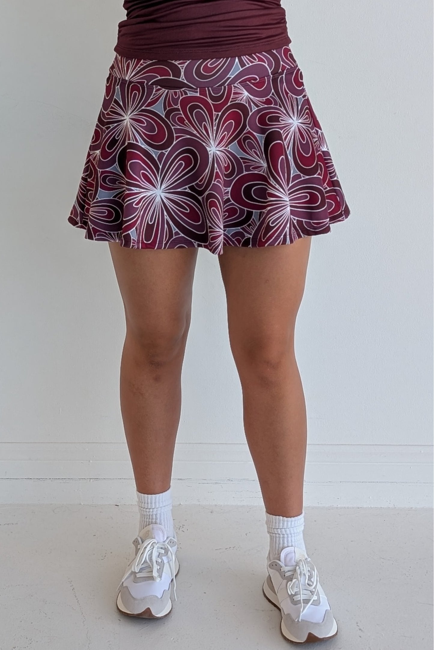 Full bodied maroon miniskirt with 70's inspired flower print and built in shorts and pockets; great for gameday or hanging out with friends.