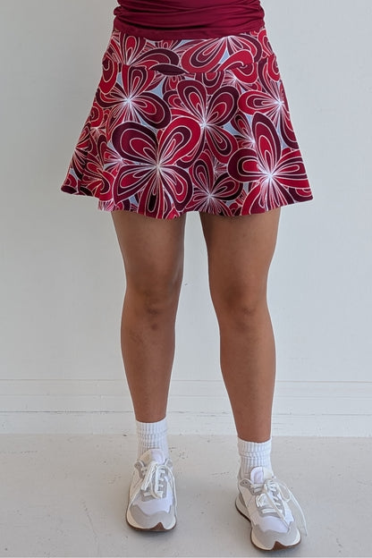 Full bodied crimson miniskirt with 70's inspired flower print and built in shorts and pockets; great for gameday or hanging out with friends.