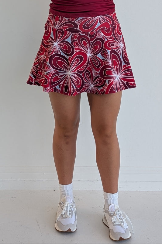 Full bodied crimson miniskirt with 70's inspired flower print and built in shorts and pockets; great for gameday or hanging out with friends.