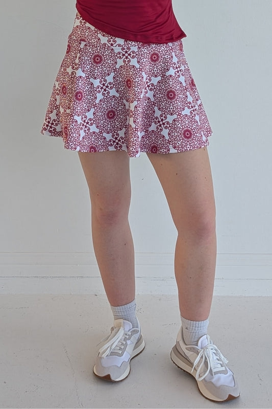 Full bodied crimson miniskirt with scroll print and built in shorts and pockets; great for gameday or hanging out with friends.