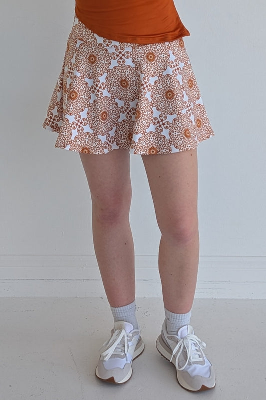 Full bodied burnt orange miniskirt with scroll print and built in shorts and pockets; great for gameday or hanging out with friends.
