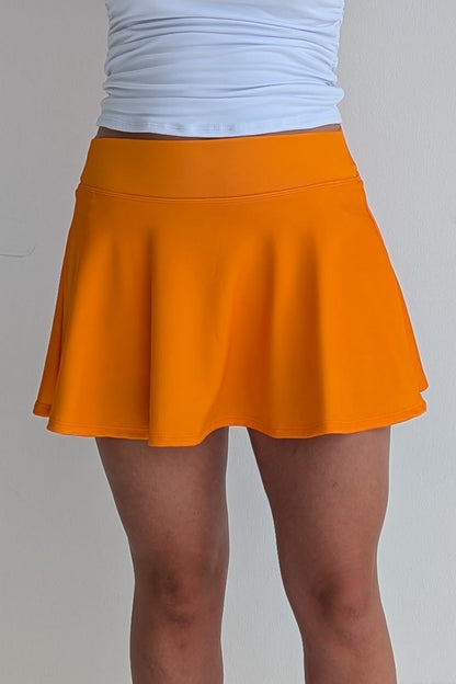 Full bodied solid orange miniskirt with built in shorts and pockets; great for gameday or hanging out with friends.